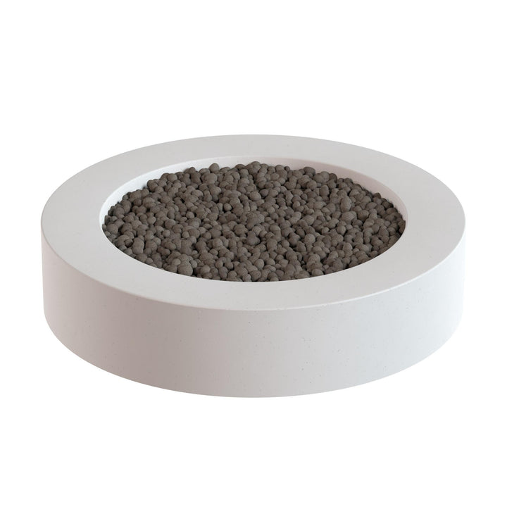 a white circular planter filled with small, dark-colored stones or pebbles.