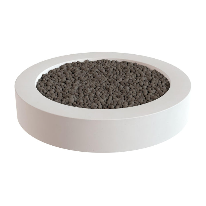 a white circular planter filled with small, dark-colored stones or pebbles.