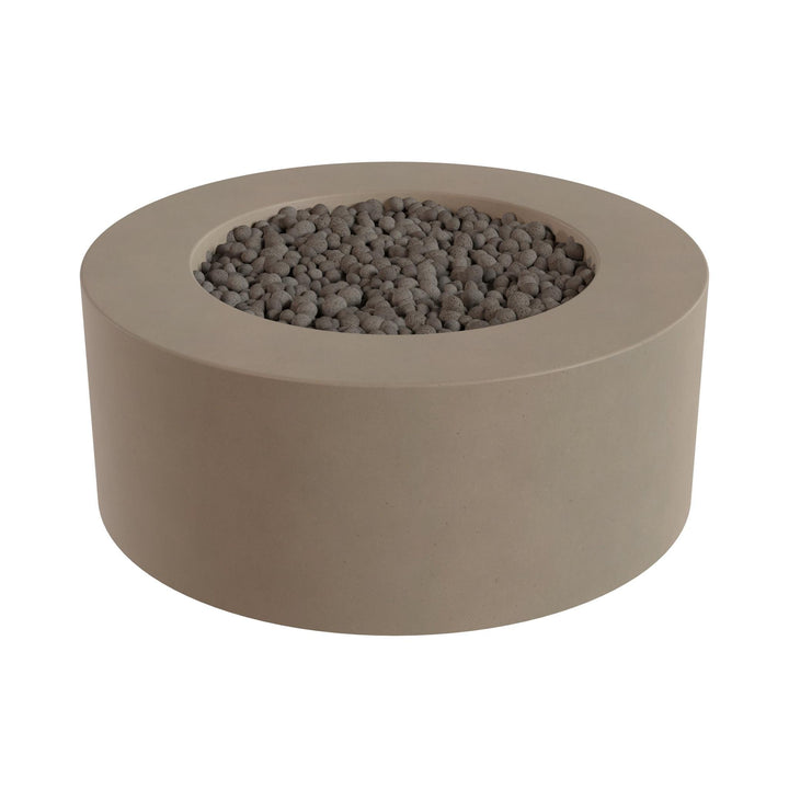 a round, beige-colored fire pit or planter filled with small gray stones or pebbles.